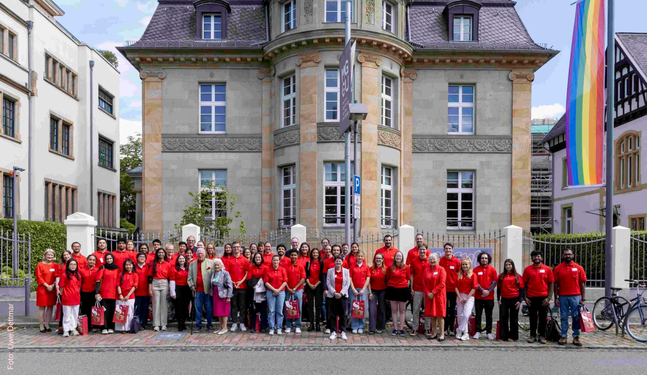 Grosse Gruppe von Studierenden vor einer Villa